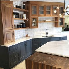 a kitchen with wooden cabinets and marble counter tops