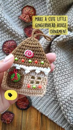 someone is holding up a small crocheted gingerbread house ornament with candy on it