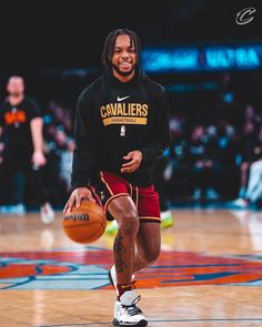 a man with dreadlocks holding a basketball