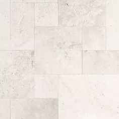 a white marble tile floor with different shades and patterns on it's surface,