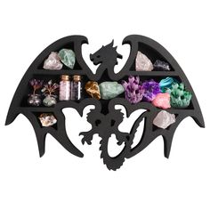 a black metal shelf with various rocks and crystals on it's sides, in the shape of a bat