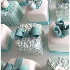 there are many small cakes with bows on the top one is white and blue, while the other is light blue