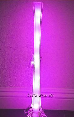 a purple lamp is lit up in the dark with its light shining down on it