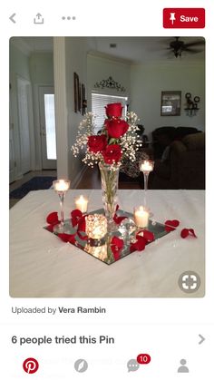 a vase with roses and candles on a table in the middle of a living room