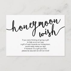 a white card with the words honeymoon wish on it in black ink, against a marble background