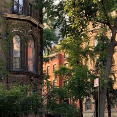 an old brick building in the middle of a park with benches and trees around it