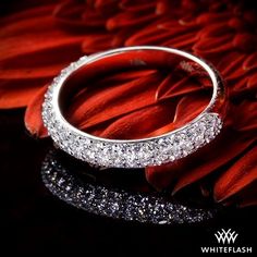 a diamond ring sitting on top of a red flower