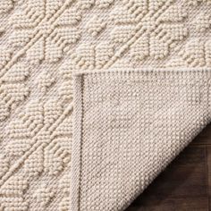 a white rug on top of a wooden floor