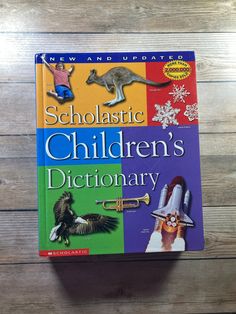 a book on children's dictionary sitting on top of a wooden table