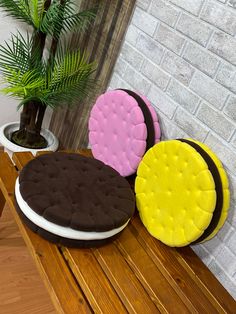 there are three cookies on the table with flowers in the vase and one cookie has been made to look like an ice cream sandwich