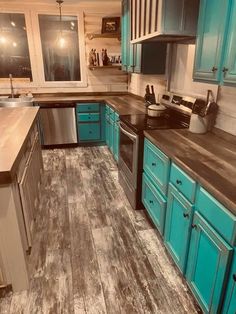 a kitchen with teal cabinets and wood flooring is pictured in this image from the front view