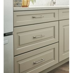 a kitchen with gray cabinets and white counter tops