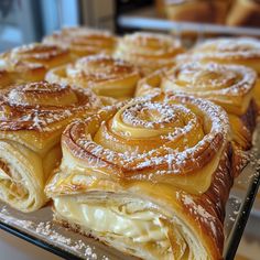 several pastries are sitting on a baking rack with powdered sugar around the edges