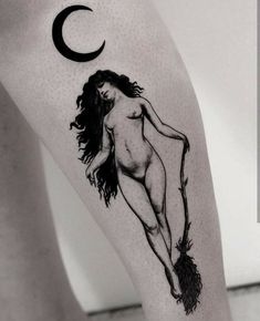 a black and white photo of a naked woman with a crescent tattoo on her leg