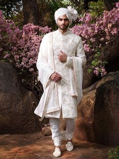 a man dressed in white is standing outside