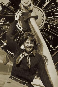 a woman standing next to an airplane with the engine on it's back end