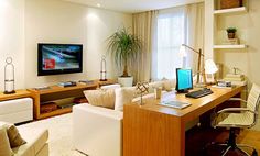 a living room filled with furniture and a flat screen tv mounted above a wooden desk