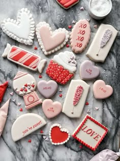 valentine's day cookies are arranged on a marble table