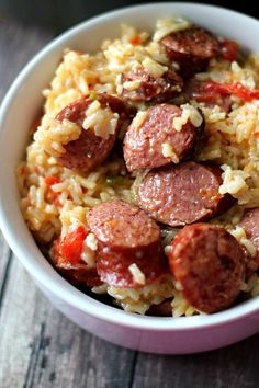 a white bowl filled with rice and sausage