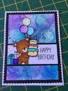 a birthday card with a teddy bear holding a cake and balloons on top of it