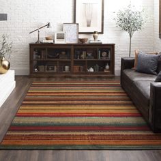 a living room filled with furniture and a rug on top of a hard wood floor