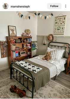 a bedroom with a bed, bookshelf and teddy bear on the floor in it