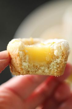 a hand holding a half eaten pastry with butter on it's side and the other half being held up