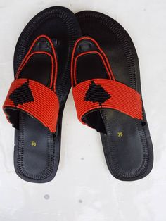 This is an African beaded sandal. It's made using soft leather and adorned with stylish masai beadwork. Its a simple yet a very stylish outstanding sandal. Casual Beaded Leather Flip Flops, Adjustable Beaded Leather Flip Flops, Summer Leather Sandals, Bohemian Sandals, Beaded Shoes, Handmade Sandals, Sandals Flat, Beaded Sandals, Maasai