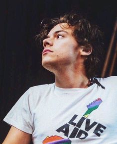 a young man wearing a white t - shirt with the words alive and rainbow on it