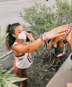 a woman wearing a face mask is taking a picture of a dog