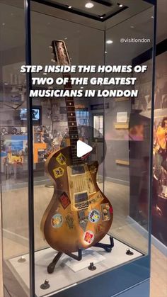 an electric guitar is on display in a glass case with the words step inside the homes of two of the greatest musicians in london