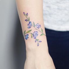 a woman's foot with a flower tattoo on the left side of her arm