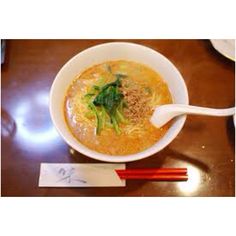 a bowl of soup and chopsticks on a table