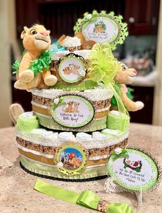 there is a baby shower cake with teddy bears on the top and green ribbon around it