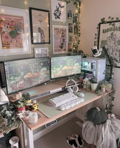 a computer desk with three monitors and two keyboards on it, surrounded by pictures and plants