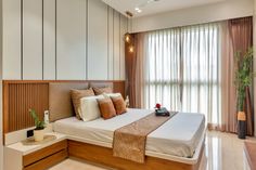 a bedroom with a large bed and wooden headboard in front of a tall window