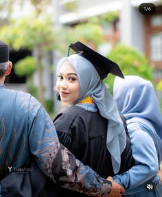 a woman in a black and blue graduation gown