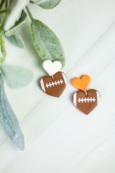 two decorated heart shaped cookies sitting on top of a table next to a potted plant