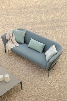 a blue couch sitting on top of a carpet covered floor next to a coffee table