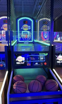 several basketballs are sitting in front of an arcade machine