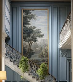 a painting on the wall next to a stair case with potted plants in it