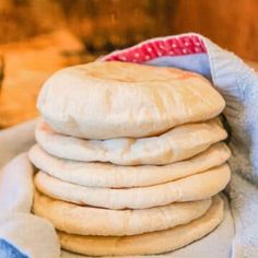 a stack of uncooked bread sitting on top of a blue and white towel