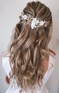 the back of a woman's head with long hair and flowers in her hair