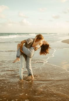 two people are hugging on the beach