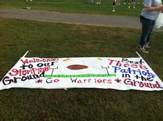 a sign on the grass that says welcome to our football team and is decorated with words