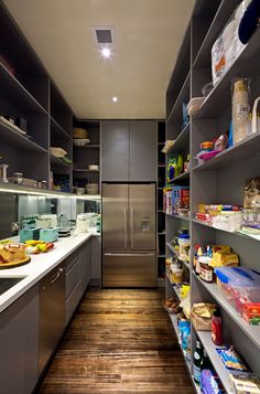 a kitchen with stainless steel appliances and shelves filled with food