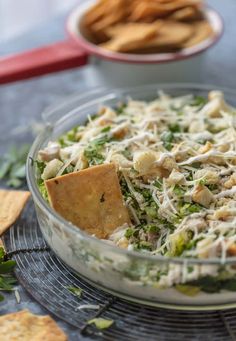 a glass bowl filled with salad and crackers