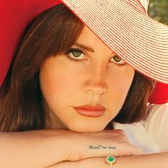 a close up of a person wearing a hat with a ring on her left hand