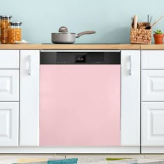 a pink dishwasher sitting on top of a kitchen counter next to white cabinets