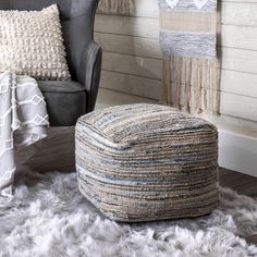 a chair and ottoman in a room with rugs on the floor next to it